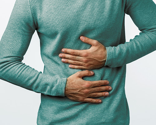 Man holding stomach due to gut problems